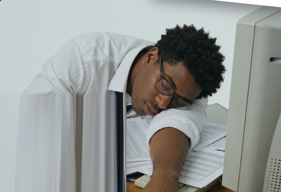 Exhausted property finance professional asleep on a pile of budget spreadsheets